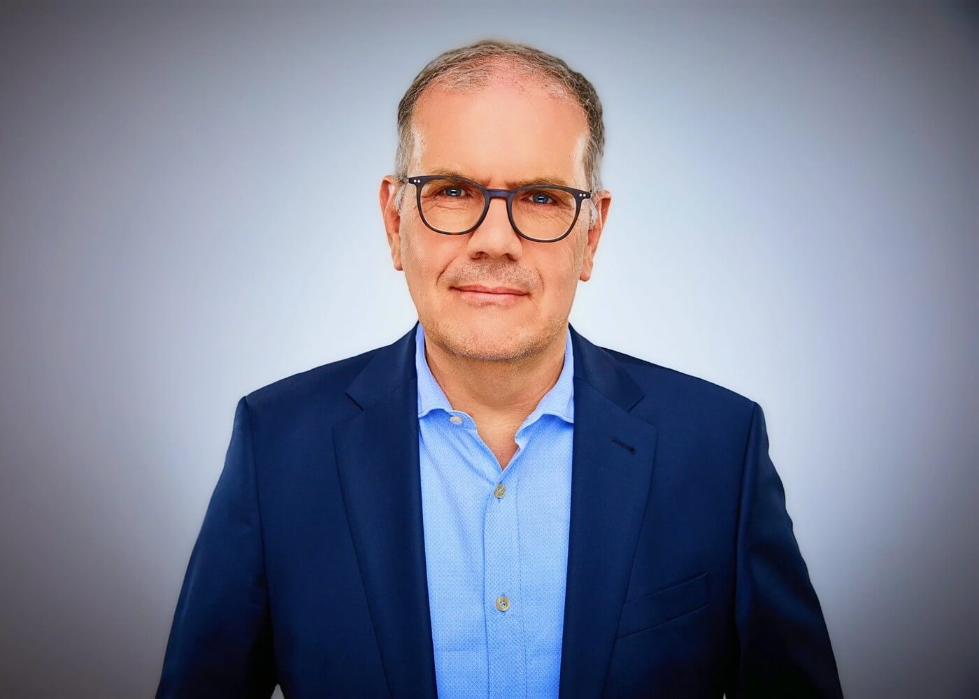 Björn Ognibeni im dunklen Anzug, ruhiger Blick in die Kamera
