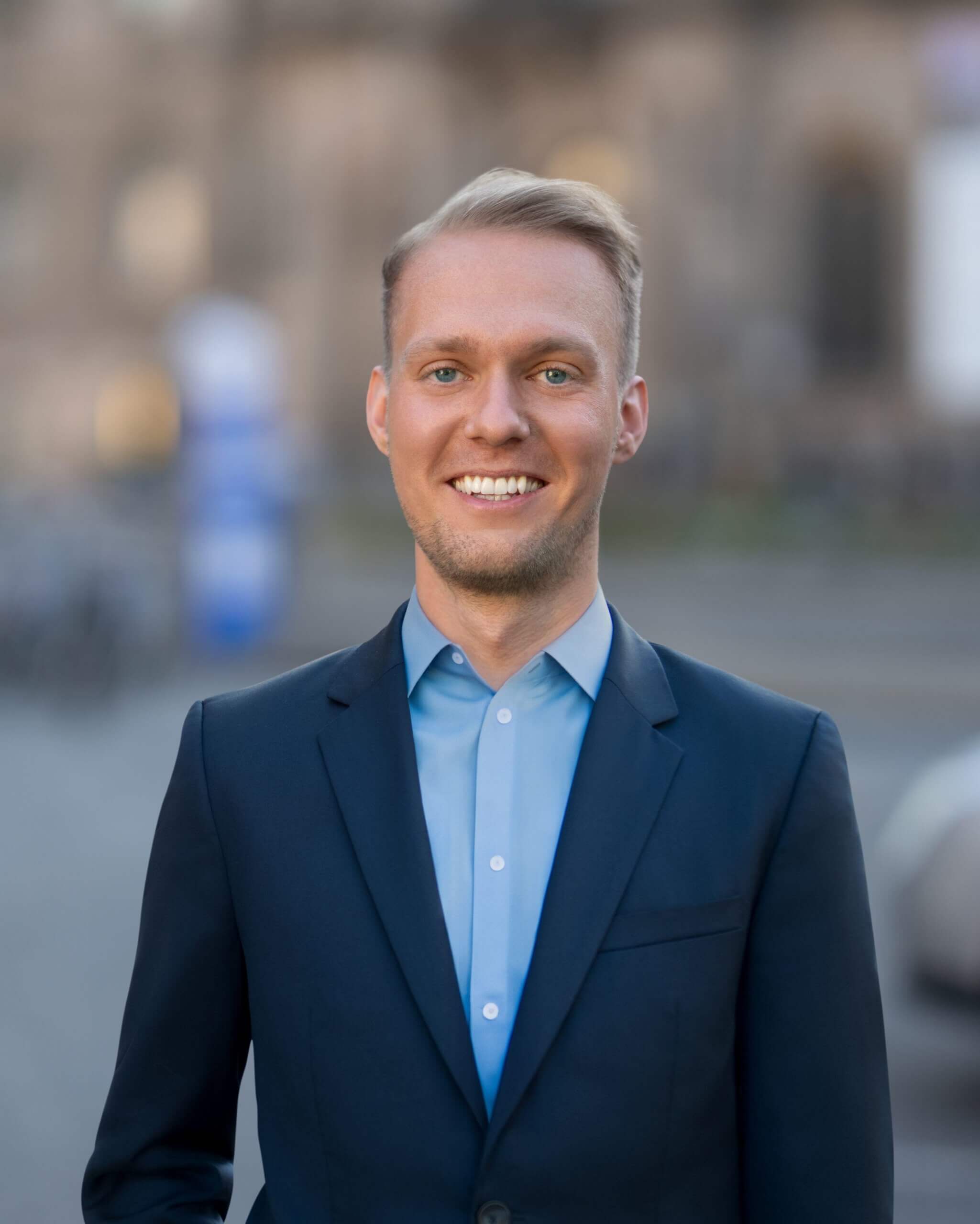 Keynote Speaker Nico Marquardt im dunkelblauen Anzug vor einem Gebäude in Berlin
