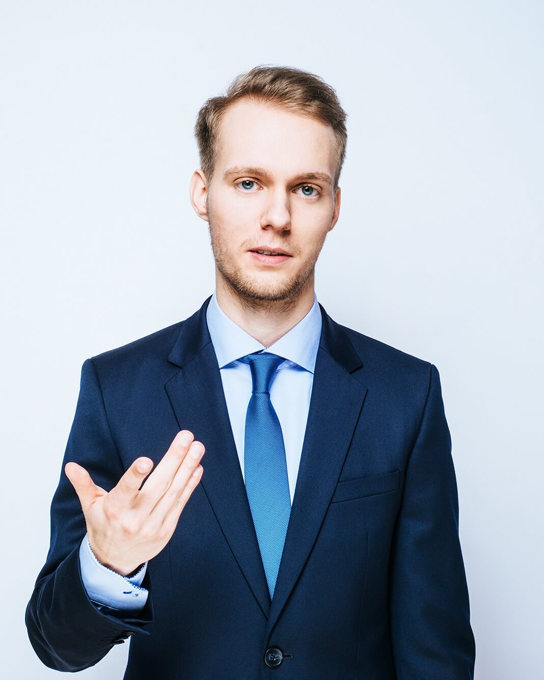 Keynote Speaker Nico Marquardt im dunkelblauen Anzug mit Krawatte, erklärende Handbewegung